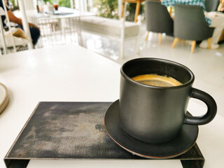 cup of black coffee on white table in coffee shop atmosphere