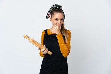 Young Lithuanian woman holding a rolling pin isolated on white background thinking an idea while looking up