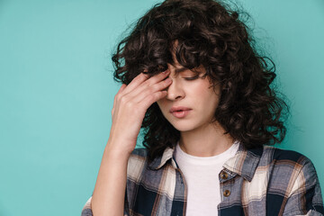 Caucasian unhappy curly girl with headache posing at camera