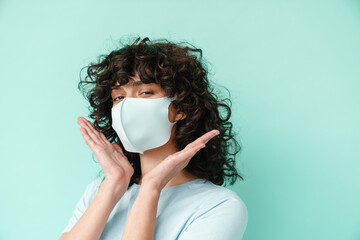 Caucasian nice curly girl in face mask posing and looking at camera