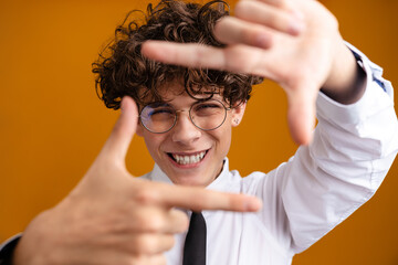 Happy excited male student standing wearing uniform