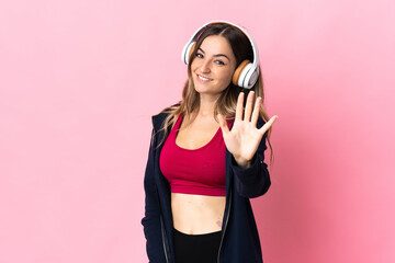 Young Romanian sport woman isolated on pink background counting five with fingers