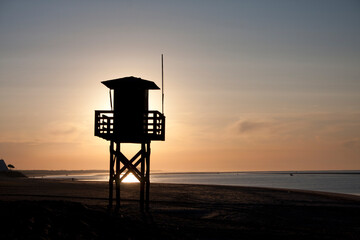 beautiful sunrise with lifeguard tower on the beach