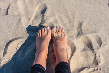 young girl feet on beach sand