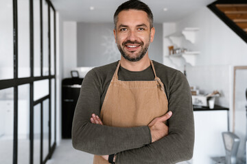 Close up of a confident young man wearing apron