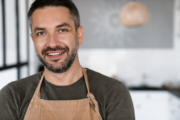 Close up of a confident young man wearing apron