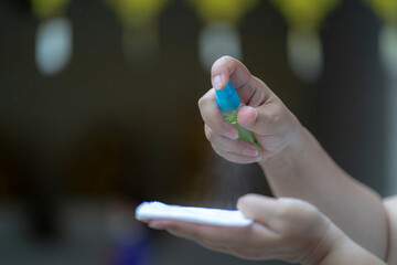 close up hand using sanitizer spray for killing bacteria and virus.