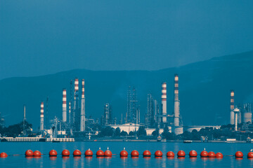 Oil refinery behind anchor buoys at sea