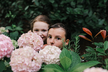 Portrait of a girl with a friend among tropical flowers and plants. Vacation, summer, holidays, nature concept.