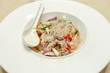 Spicy Glass Noodle Salad with Squid on white plate.