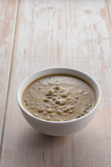 Mung beans porridge (bubur kacang hijau) is a Malaysian traditional dish usually eat as starter or desert. Made from mung beans, coconut milk & palm sugar. Isolated over wooden background.