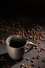 Cup of coffee and coffee beans on a black table