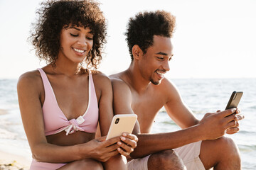 Beautiful young african couple using smartphone