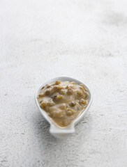 Mung beans porridge (bubur kacang hijau) is a Malaysian traditional dish usually eat as starter or desert. Made from mung beans, coconut milk & palm sugar. Isolated over wooden background