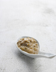 Mung beans porridge (bubur kacang hijau) is a Malaysian traditional dish usually eat as starter or desert. Made from mung beans, coconut milk & palm sugar. Isolated over wooden background