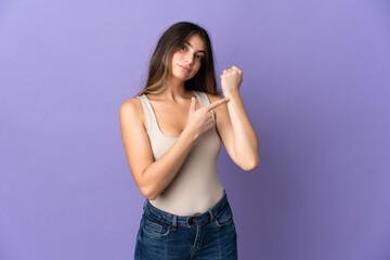 Young caucasian woman isolated on purple background making the gesture of being late