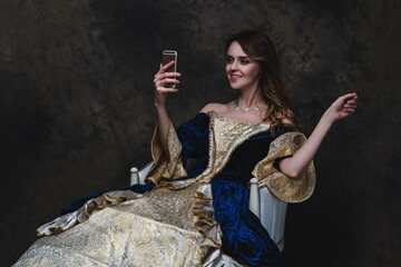 Beautiful happy woman in renaissance dress taking selfie on smartphone, old and new concept