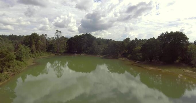 Pristine Green Guarne Lagoon in the Middle of the Woods near Medellin, Colombia on a Cloudy Day shot from in Smooth Travelling form Above