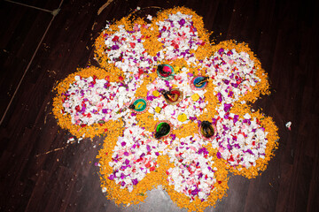 Floor decorated with diyas and flowers on the occasion of diwali