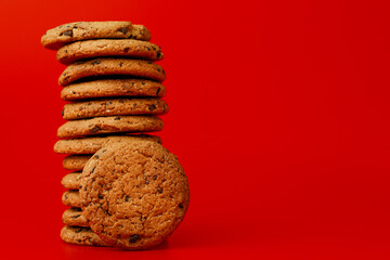 Chocolate chip cookies in stack on red background