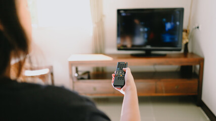 Watching smart  TV and using remote controller tv Hand holding television  audio remote control  with the remote control television.