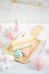 Fototapeta na wymiar Unicorn Cake. A sweet pastel unicorn cake with macarons on the side for little girl's birthday party.