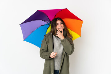Young caucasian woman holding an umbrella isolated on white background happy and smiling