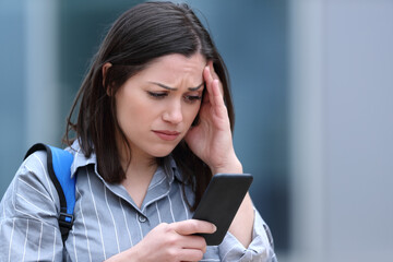 Worried student checks smart phone message