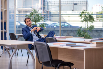 Young male teacher in suit in the classroom