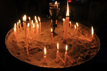 Lighting candles inside a Greek orthodox church.