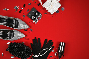 Women's fashion accessories on a red background with copy space. Time to party concept.