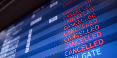 Flight information board displaying cancelled flights in international airport during COVID-19...