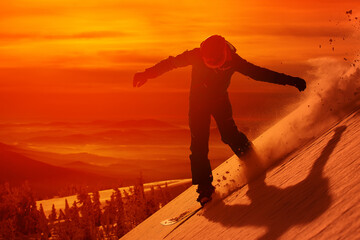 snowboarder is riding with snowboard from sunset