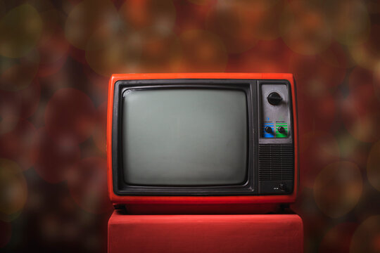 Retro old TV on red wooden box with bokeh background