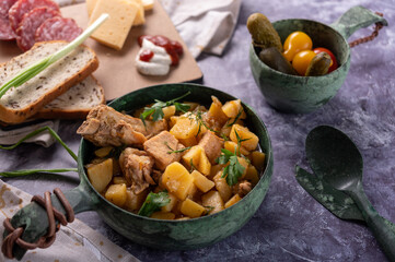 Potatoes with meat and herbs. Meat and cheese cuts. Dinner setting.