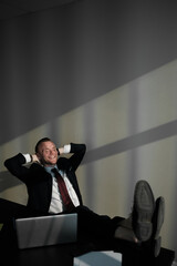 Fototapeta premium Handsome businessman is keeping arms raised and expressing joyful in office.