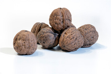 walnuts in close-up on white - composition of a group of walnuts - seasonal fruit