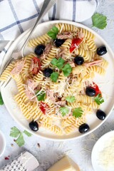 Fusilli pasta with tuna, olives, tomato and parmesan cheese. Top view with copy space. Healthy food.
