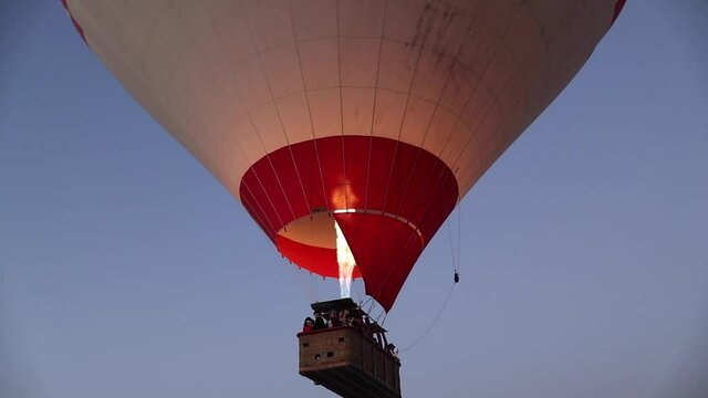 Hot Air Balloons taking over Cappadocia, Goreme, Turkey. The view of valley, rocks, fairy chimneys and people watching sunrise. 