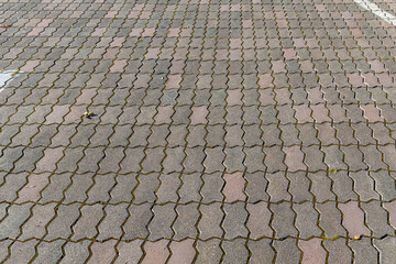 Texture of gray paved path is in the park in autumn