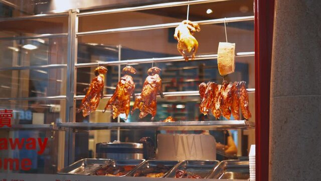 Roasted meat hanging behind the window of a Chinese restaurant