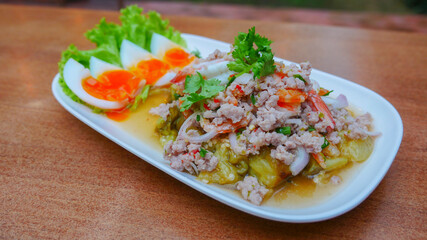 closeup dish of spicy grilled eggplant salad with boiled eggs