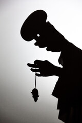 play shadow projected against a white background. a cook and mouse.