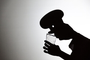 play shadow projected against a white background. a cook