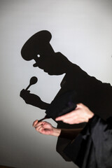 play shadow projected against a white background, a cook