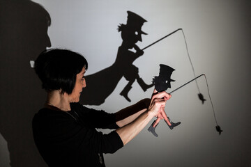 play shadow projected against a white background. a homeless man with a rod fishing
