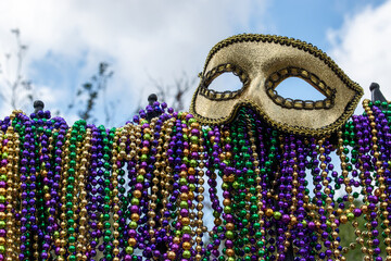 iron fence covered with Mardi Gras beads topped with golden mask © Lynne Ann Mitchell