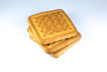 Square shortbread biscuits on the white background with ornament on it. Pile of cookies, warm home food photo photo, instagram layout. Quadrate cookies.