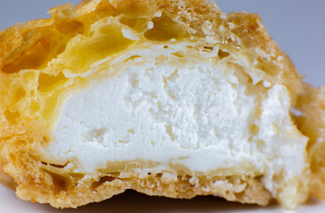 Cupcake with cream on the white plate. Sweet dessert for breakfast. Close up view of cut in half cake inside.