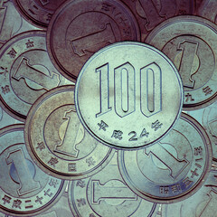 100 yen lies on a pyramid of Japanese 1 yen coins. View from above. Inverted colors. Square unusual catchy illustration on a financial theme. News about economy of Japan. Deposits and interest. Macro